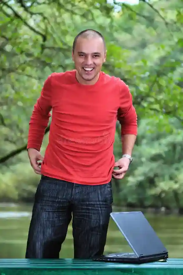 hombre-de-negocios-joven-en-la-camisa-roja-que-trabaja-en-la-computadora-portátil-7415446.webp