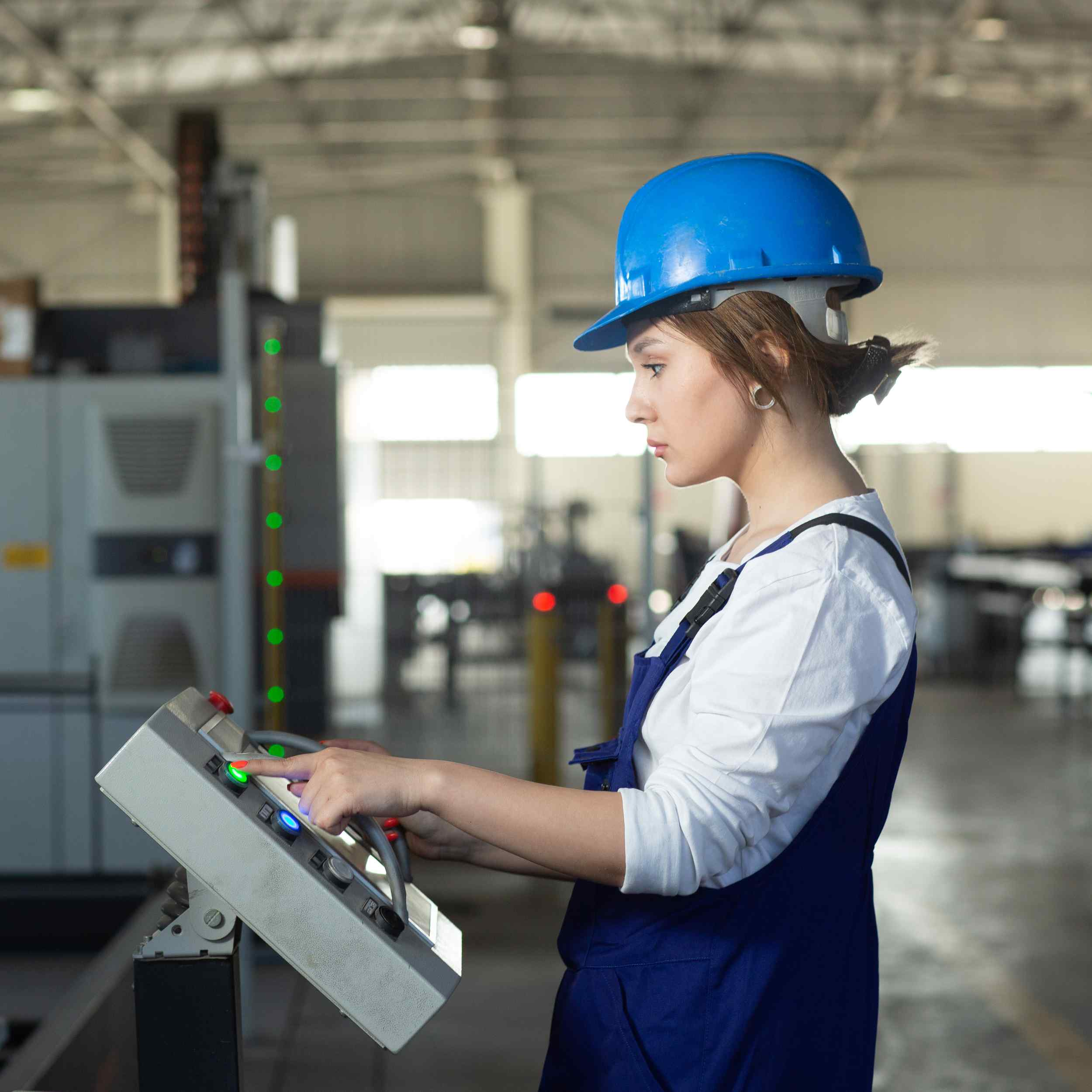 front-view-young-attractive-lady-blue-construction-suit-helmet-controlling-machines-hangar-working-daytime-buildings-architecture-construction.jpg