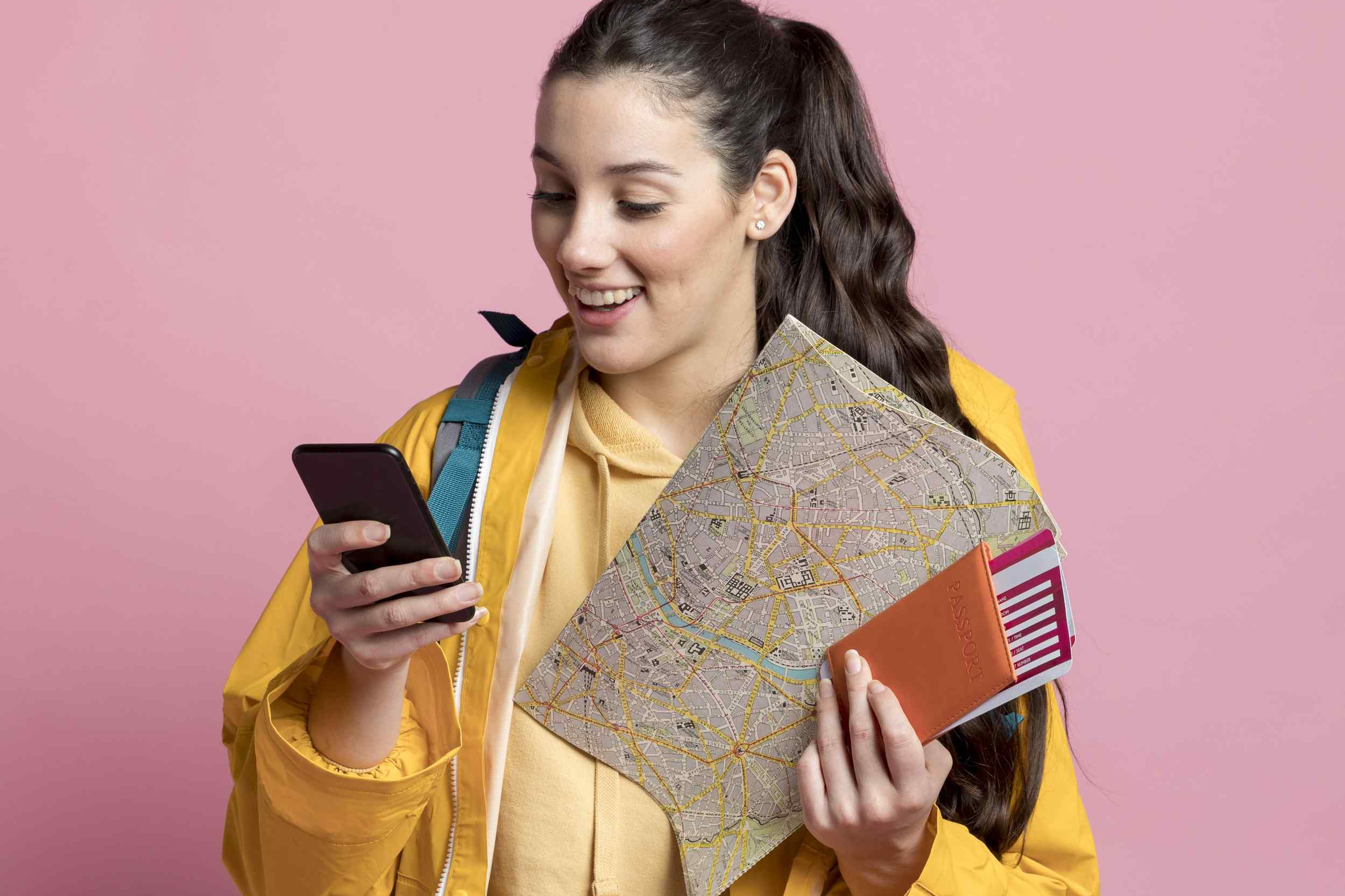 mujer-sonriente-revisando-su-telefono-mientras-sostiene-un-mapa-y-su-pasaporte.jpg
